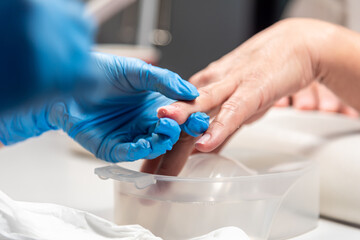 Performing manicure work in a beauty salon.