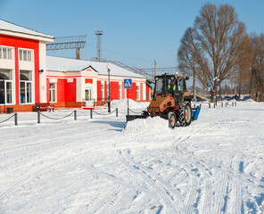 Samara, Chapaevsk, Russia-February.20.2018: Snow plow truck cleaning forecourt area streets Winter snow removal concept city landscape background horizontal - obrazy, fototapety, plakaty