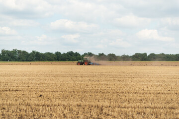 traktor mäht feld im sommer ackerbau