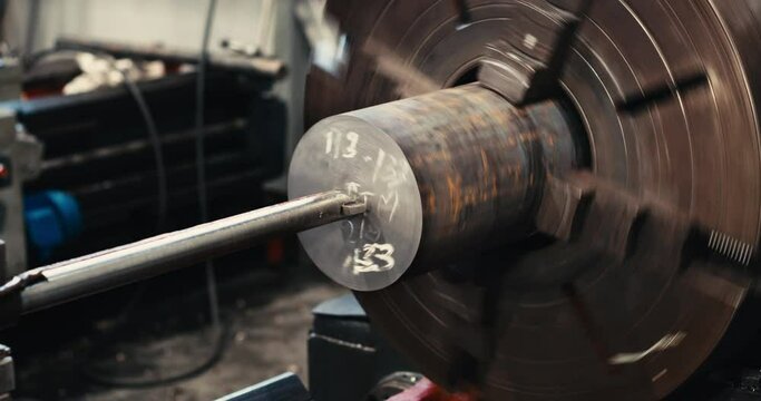 Close-up of an aluminum alloy cylindrical billet turning on a lathe. cutting head with carbide insert. Chip processing.