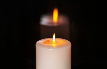 Candle with burning glowing light in dark night. Candlelight.