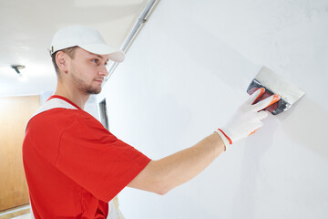 Plasterwork and wall painting preparation. craftsman applying plaster or filling