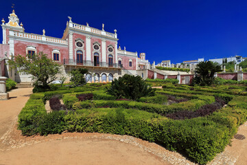 Fototapeta na wymiar South fa?ade-neoRococo palace-gravel path-trimmed hedges-clock tower-long balcony-porthole windows-rooftop statues. Estoi-Algarve-Portugal-029