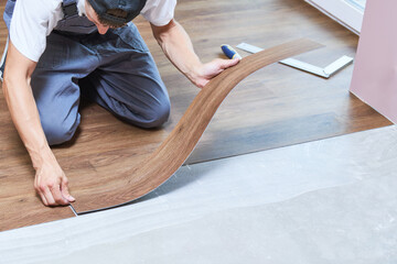 worker joining vinyl floor covering at home renovation - obrazy, fototapety, plakaty