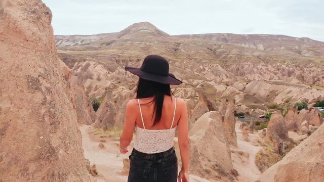 Caucasian Woman tourist enjoy freedom and travel holidays outdoors walk don among fairy chimneys in devrent valley , Cappadocia