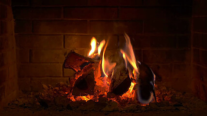 burning fire in a brick fireplace close-up shot