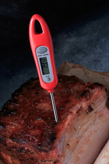 Crispy Roast Pork Belly. Roasted meat and meat thermometer in a cooked meat.

