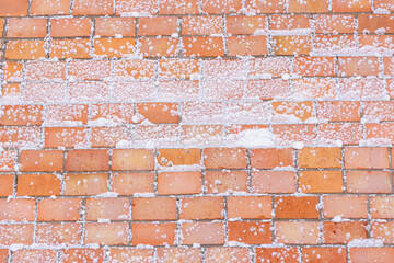 Snow-covered wall. Brick wall of a house in the snow.