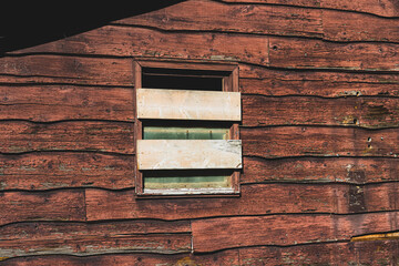 Boarded up window on abandoned log cabin. 