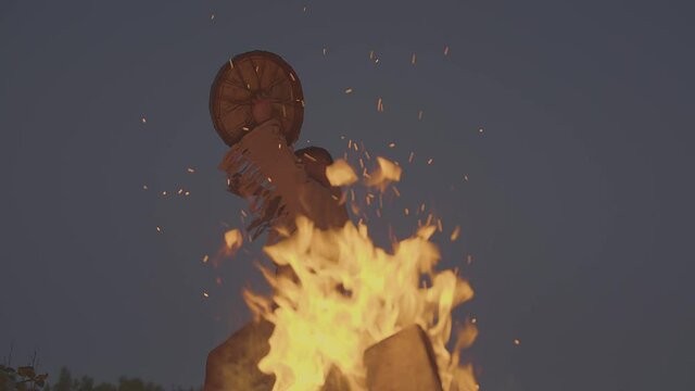 A shaman with a drum jumps in around the fire in clothes for the ceremony.