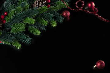 christmas black background with spruce branch and christmas tree toy ball