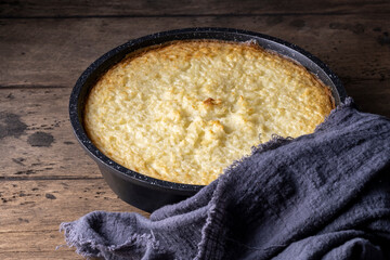 Baking dish with tasty rice casserole on wooden background