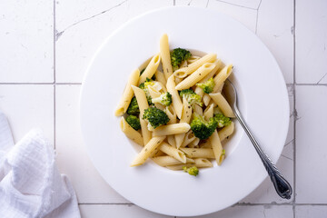pasta with broccoli on a white plate and white ceramic background. top view.