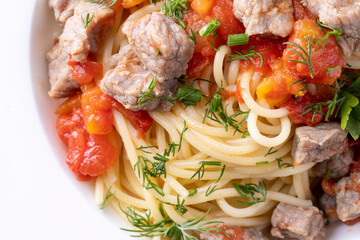 Pasta in tomato sauce and meat on white plate and white background.