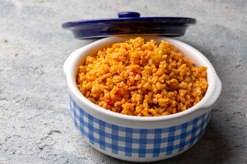Traditional turkish bulgur pilaf with tomato sause in plate (Turkish name; meyhane pilavi)