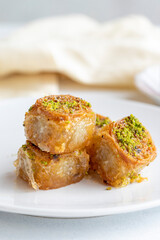Pistachio baklava dessert on a white background. Turkish sweet dessert concept. plate of pistachio baklava. sherbet sweet Mediterranean bakery. close up. selective focus.