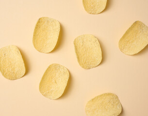 round potato chips on a beige background, top view