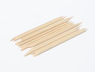 set of orange wooden manicure sticks on white background