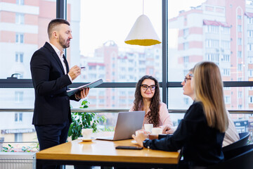 The boss stands with the charts, demonstrates statistics, various personnel attending the training, introduces the company's new products, reports on the results of work for partners.