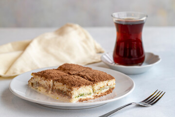 Cold baklava on a dark background. Turkish sweet dessert concept. plate of sliced forest fruit cake. Plate of cold milk baklava. Mediterranean bakery. close up. selective focus. soguk baklava