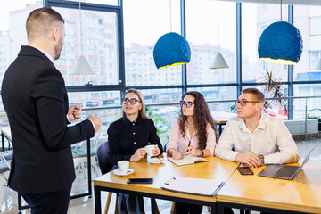 The boss stands with the charts, demonstrates statistics, various personnel attending the training, introduces the company's new products, reports on the results of work for partners.