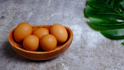 Eggs in a wooden bowl on a table that is neatly and simply arranged which gives an elegant and exclusive impression. Food and drink concept. Food & beverages.