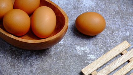Eggs in a wooden bowl on a table that is neatly and simply arranged which gives an elegant and exclusive impression. Food and drink concept. Food & beverages.
