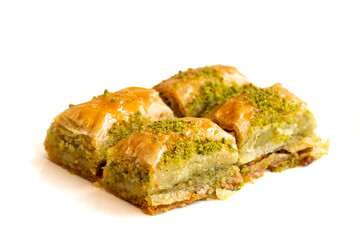 Pistachio baklava dessert isolated on white background. Turkish sweet dessert concept. close up pistachio baklava. sherbet sweet Mediterranean bakery selective focus. Horizontal view.