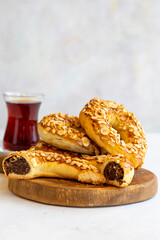 Turkish Ay coregi and tea. moon cookie on white background. Croissant with chocolate cocoa and raisin. Close up. Selective focus. Vertical view. Story format