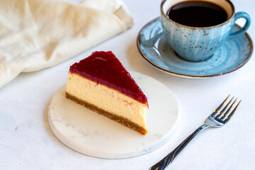 Cheesecake on white background. Greek sweet dessert concept. plate of sliced cheesecake. Cheesecake with raspberry gel filling. Mediterranean bakery. close up. selective focus. Horizontal view.