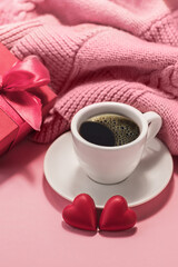 Cup of coffee, two chocolate hearts and a gift box on a pink background. Love, birthday, engagement and Valentine's Day concept. Festive background.