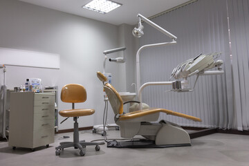 Dental clinic, with chair and medical equipment empty, white , orange seats 