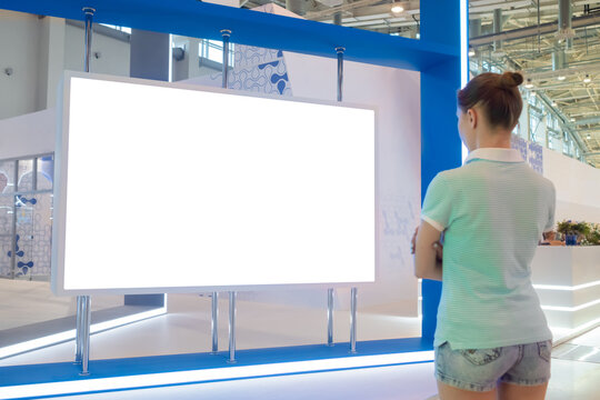 Woman Looking At Blank Digital Interactive White Display Wall At Exhibition Or Museum With Futuristic Scifi Interior. White Screen, Mock Up, Future, Copyspace, Template, Technology Concept