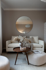 Scandinavian living room interior with round mirror on wall. 