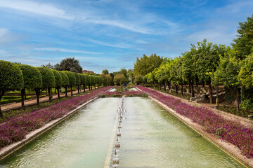 Fountains, orange trees, flowers in the gardens in the Alcazar de los Reyes Cristianos in Cordoba, Spain