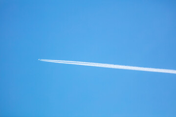The Contrail from a High Flying Airliner Leaving a Cloud Streak in a Blue Sky as the Hot Steam Quickly Condenses as it Leaves the Engines