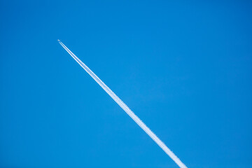 The Contrail from a High Flying Airliner Leaving a Cloud Streak in a Blue Sky as the Hot Steam Quickly Condenses as it Leaves the Engines