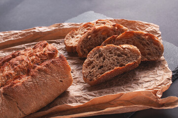 sliced bread lying on black board for serving on parchment paper.
