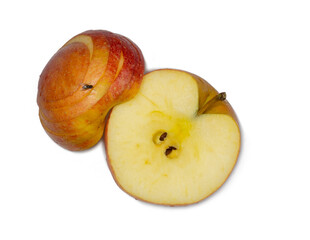 A large red apple cut into wedges. Fresh fruit isolate. A fly sits on an apple. Half of the fruit is cut.