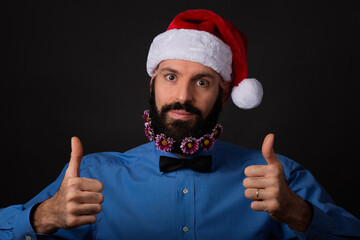 Christmas, holidays, barbershop and style concept - handsome bearded santa claus man with small flowers in long beard showing ok sign with both hands
