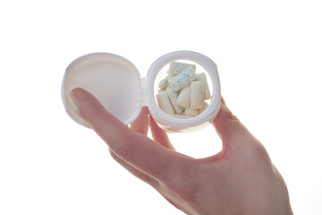 Bubble gum pads in a jar in hand isolated on a white background .Dental and oral health. Chewing...