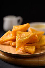 Deep fried Burmese tofu made from flour and chickpeas on black background