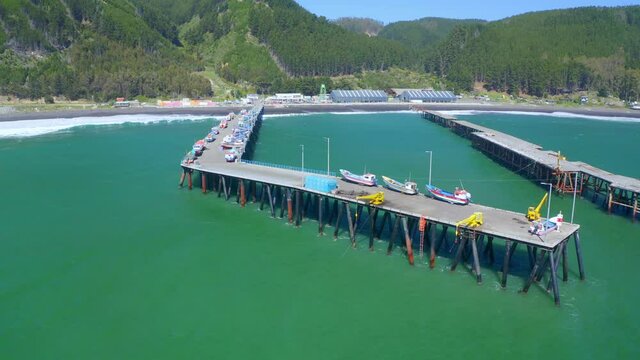 port or caleta meguellines, constitucion chile drone shot sunny day with fishing boats orbital drone shot