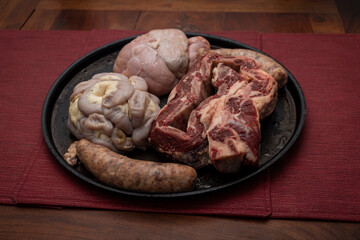 Fresh raw meat in steel tray on textured background.
