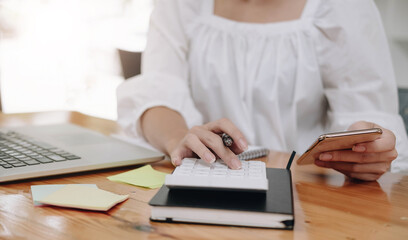 Fototapeta premium woman using smartphone, calculating browsing online banking service, checking balance, analyzing financial documents.