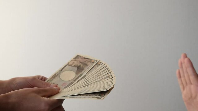 扇型にして差し出されたお金を拒否する
