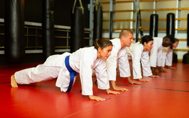 Training a group of athletes before karate training - push-ups and muscle warm-up