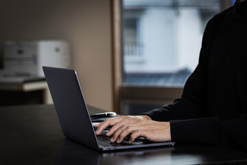 暗いオフィスでパソコンを操作する男性