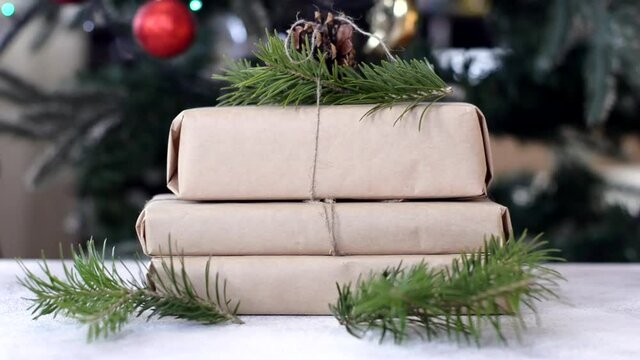 zero waste christmas gift decorated pine cone and fir branch with craft paper, no plastic holidays with lights garland christmas tree at home.