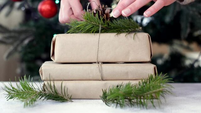 zero waste christmas gift decorated pine cone and fir branch with craft paper, no plastic holidays with lights garland christmas tree at home.